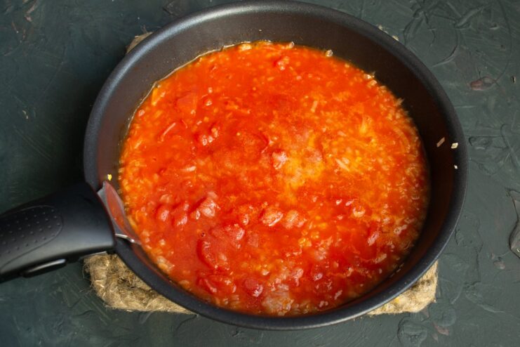 Simmering the Tomato Sauce for the Fish Casserole Tomato sauce simmering in a pan on the stove.