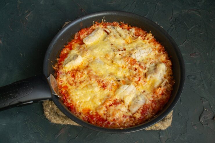 Baking the Fish and Rice Casserole in the Oven The fish and rice casserole in a baking dish going into a preheated oven.