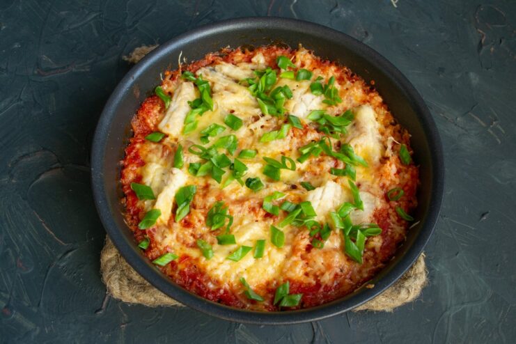 The Finished Fish and Rice Casserole, Ready to Serve A golden-brown baked fish and rice casserole in a dish, garnished with fresh herbs.