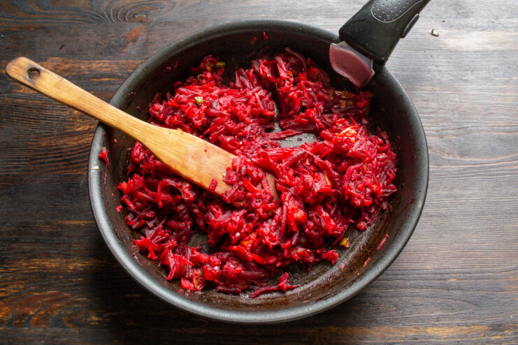 Simmering the borscht dressing to meld all the flavors together. The borscht dressing simmering in a large pot on the stove.