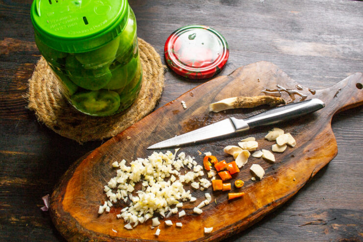 Preparing the Aromatics - Finely Chopping Garlic for the Brine Close-up of finely chopped garlic cloves on a cutting board.