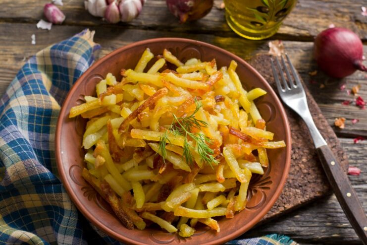 A skillet filled with golden-brown, crispy oven-fried potatoes, ready to be served.