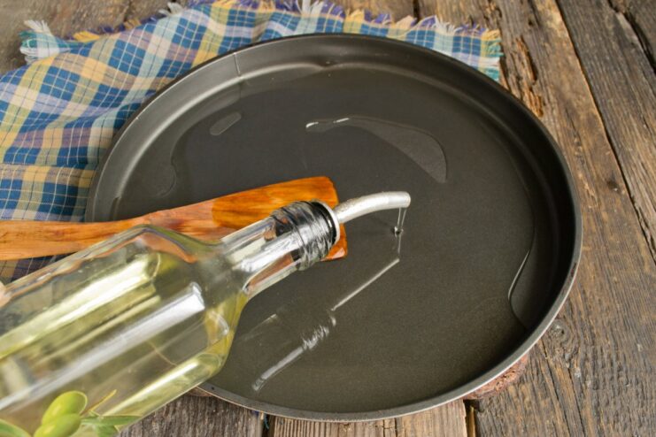 Step 6: Preheating oil in an oven-safe skillet A black cast-iron skillet with oil inside a preheated oven.