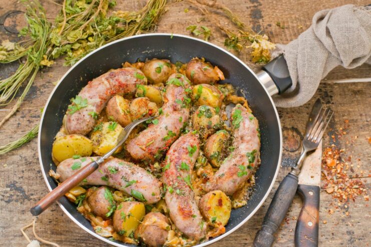 Serving the Rustic Sausage and Potato Skillet A rustic skillet of fried sausage and potatoes served family-style, ready to eat.