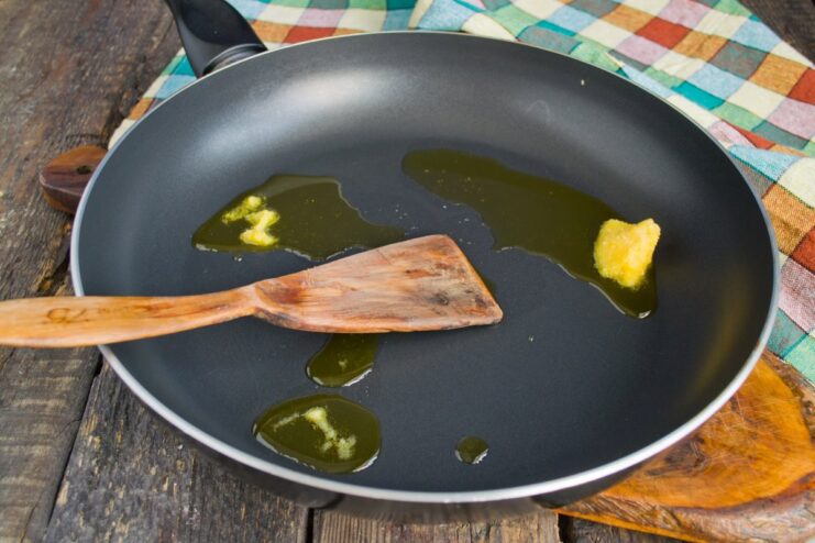 Melting Clarified Butter for Frying A piece of clarified butter (ghee) melting in a non-stick frying pan.