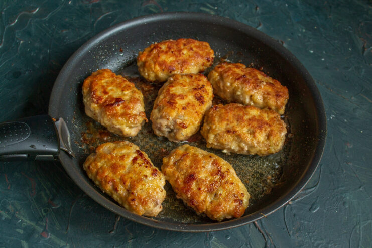 Frying Zrazy to a Perfect Golden Brown Breaded zrazy frying in a pan with hot oil, turning a beautiful golden-brown color.