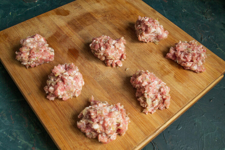 Portioning the Minced Meat for Each Zrazy A portion of minced meat on a kitchen scale, weighing approximately 65 grams for one zrazy.