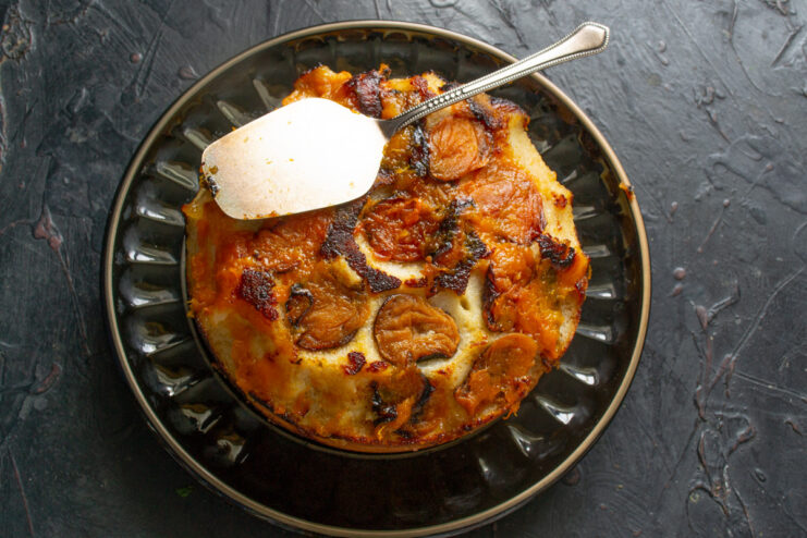 Inverting the freshly baked cake onto a wire rack A freshly baked apricot upside-down cake being flipped onto a cooling rack.