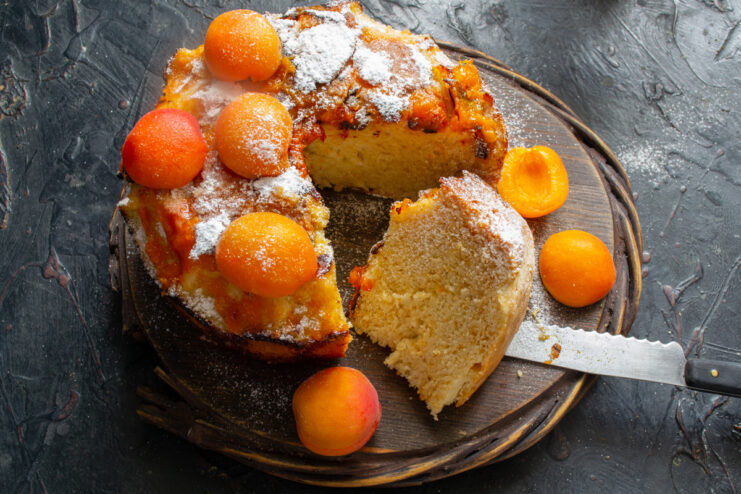Serving the warm apricot upside-down cake The finished apricot upside-down cake on a serving plate, dusted with powdered sugar.