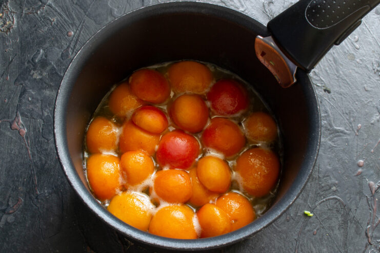 Slightly cooled caramelized apricots ready for the batter A skillet with caramelized apricot halves, slightly cooled and ready for the next step.