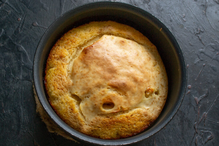 Baking the apricot upside-down cake in the oven The apricot upside-down cake baking in the oven, with the batter rising and turning golden.