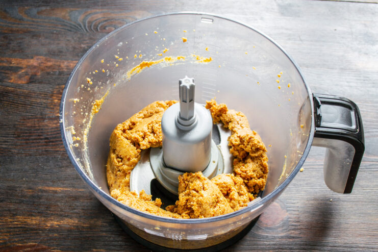 Blending all ingredients into a smooth paste The peanut and date mixture being blended together into a thick paste.
