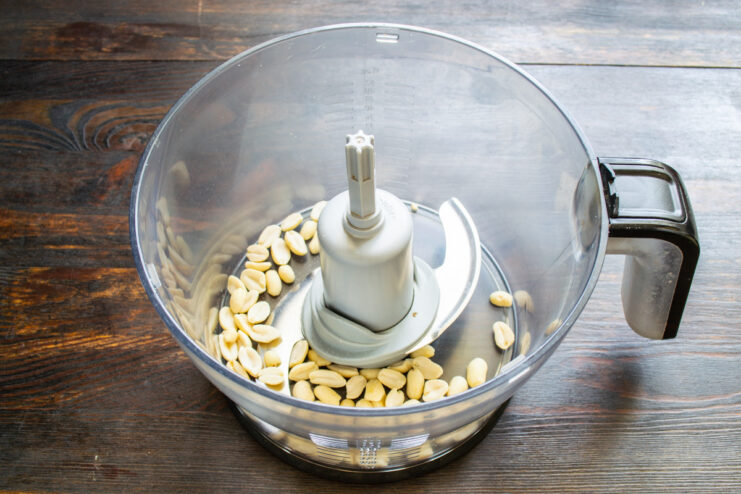 Step 1: Blending the Peanuts for the Smoothie Blanched peanuts being poured into a blender bowl.