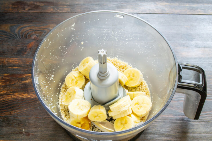 Step 2: Adding Banana for Natural Sweetness Sliced banana being added to ground peanuts in a blender.