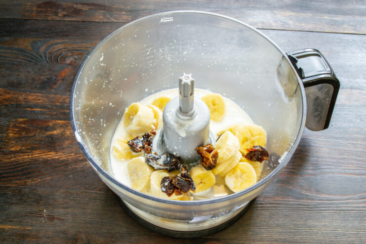 Step 5: Combining All Smoothie Ingredients Cooled milk being poured into the blender with peanuts, banana, and dates.