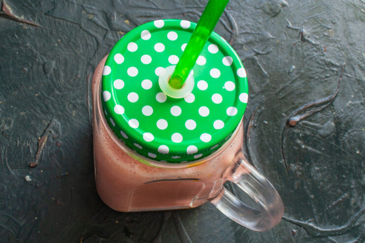 Serving the Freshly Made Watermelon Smoothie Pouring the finished pink watermelon smoothie into a glass mug.