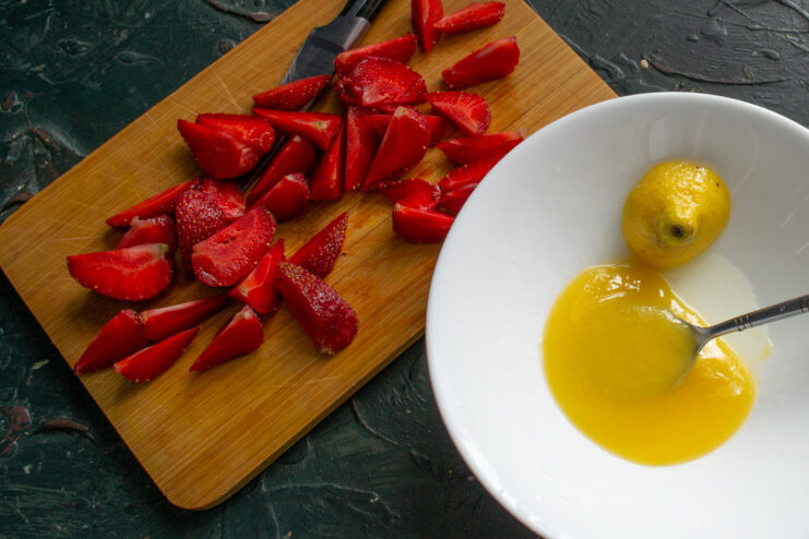 Honey and freshly squeezed lemon juice being mixed together in a small bowl.
