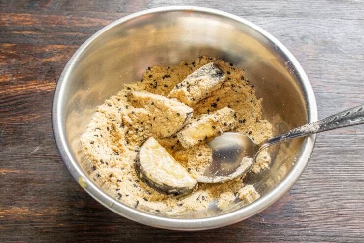 The Three-Step Breading Process for Maximum Crunch Eggplant pieces being double-coated, first in egg wash and then in a breadcrumb mixture.