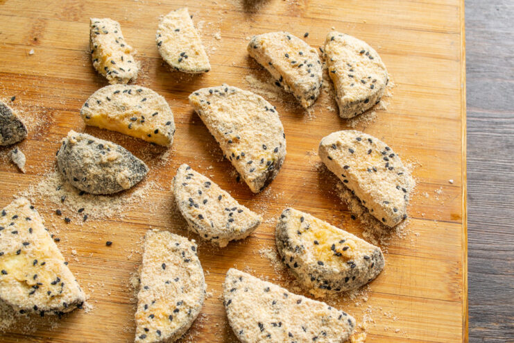 Breaded Eggplant Ready for Frying Pieces of eggplant, fully coated in breading, arranged on a cutting board before frying.