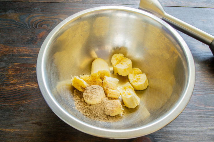 Mashing ripe bananas for the banana bread batter A ripe banana being mashed with a fork in a white bowl.