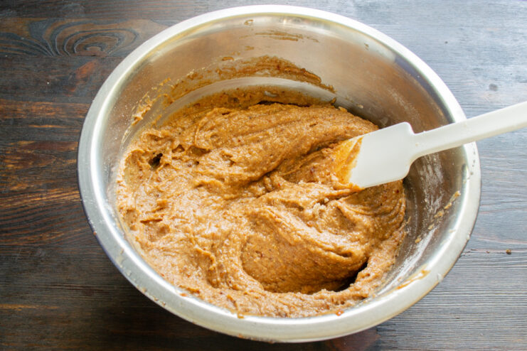 Letting the finished banana bread batter rest before baking A bowl of smooth, prepared banana bread batter resting on a countertop.