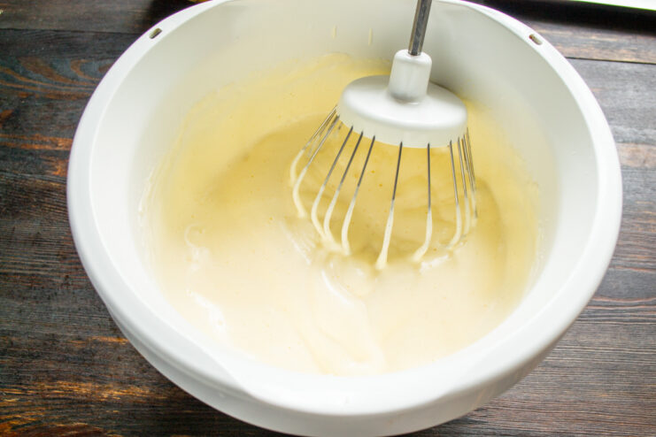 Whipping eggs and sugar until light and fluffy is key for a perfect sponge. Eggs and sugar being whipped in a mixer, creating a pale and voluminous batter.