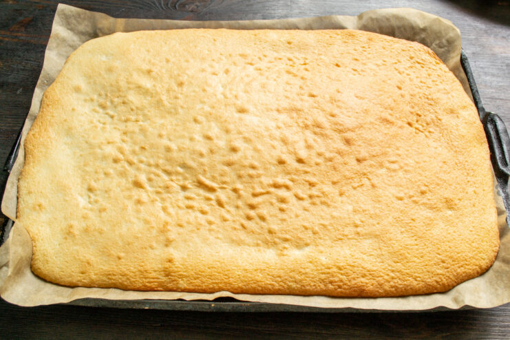 Baking the Sponge Cake Layer in the Oven Baking tray with sponge cake batter going into a preheated oven.