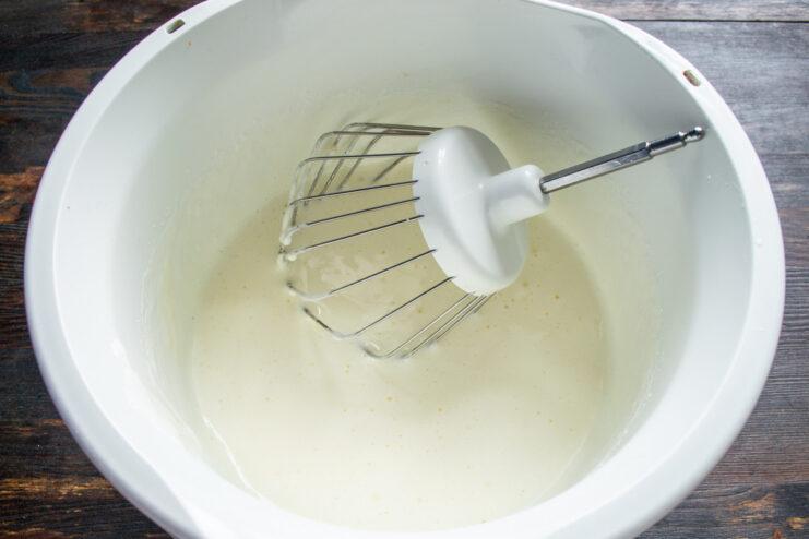 Whipping Eggs and Sugar Until Light and Fluffy A stand mixer whipping eggs and sugar into a pale, voluminous mixture.