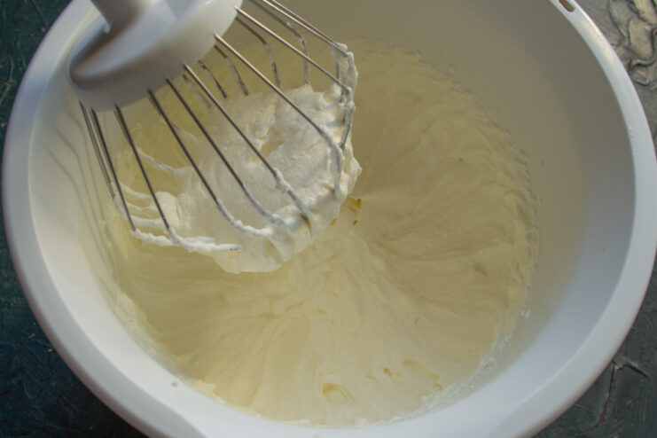 Whipping the Cream to a Thick Consistency Using a hand mixer to whip the cottage cheese cream in a bowl until it's thick and holds its shape.