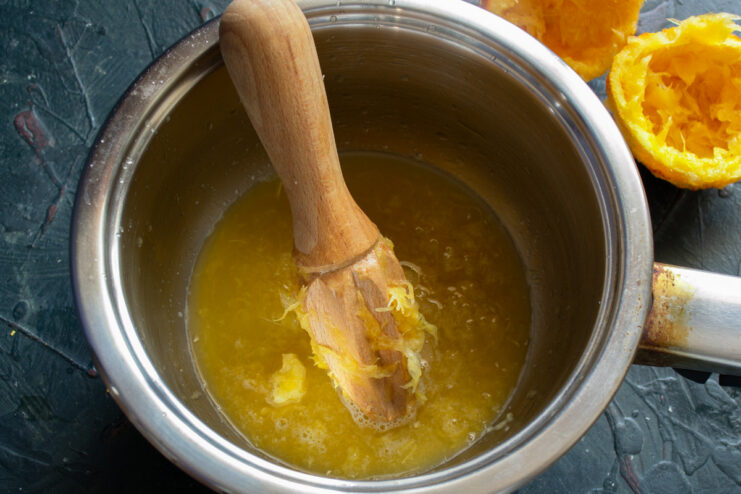 Squeezing Fresh Orange Juice for the Syrup Squeezing a fresh orange to make juice for the cake syrup.