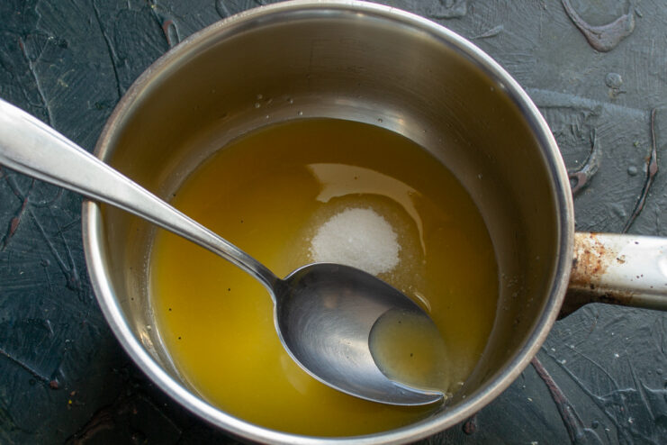 Making the Orange Syrup for Soaking the Cake Heating orange juice and sugar in a small saucepan to create a syrup.