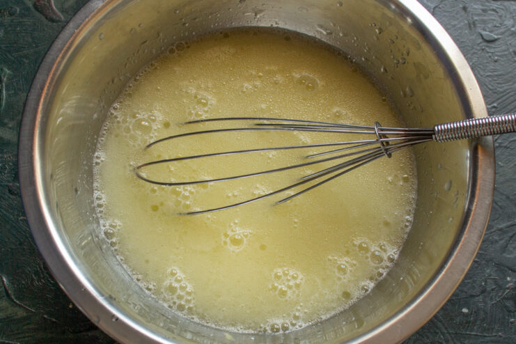 Step 1: Whisking the wet ingredients for the crepe batter A bowl with wet ingredients for crepe batter being whisked.