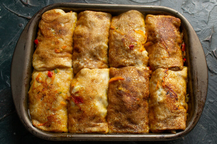 Getting ready to bake: Covering the dish to keep moisture in A baking dish with stuffed blinchiki, covered with aluminum foil, ready for the oven.