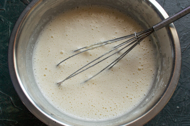Step 3: Letting the crepe batter rest for a perfect texture A bowl of smooth crepe batter resting on a countertop.