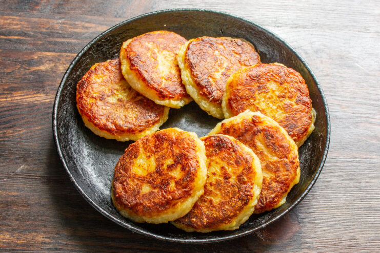 Golden-brown fried Boxty pancakes resting on a paper towel-lined plate.