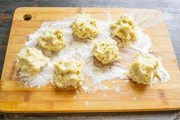 Portions of Boxty dough on a floured wooden board.