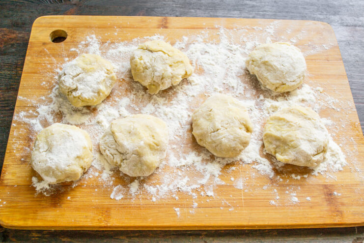 A spatula pressing down on a ball of Boxty dough to form a pancake shape.