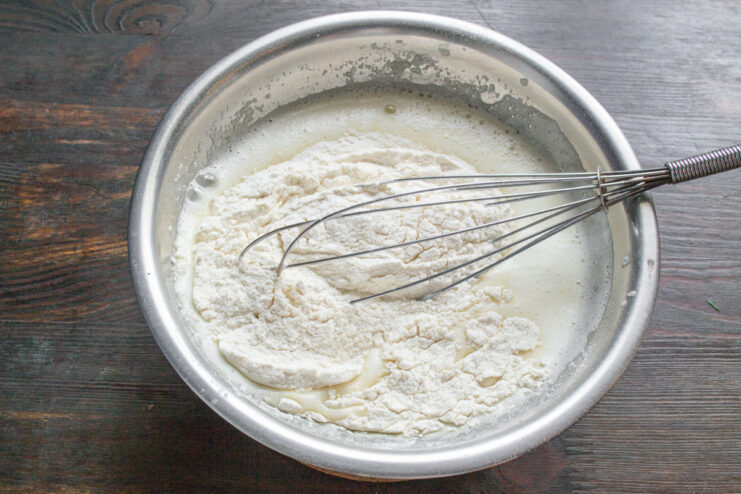 Step 4: Gradually adding dry ingredients to the wet mixture. Sifting dry flour mixture into the wet ingredients in a glass bowl.