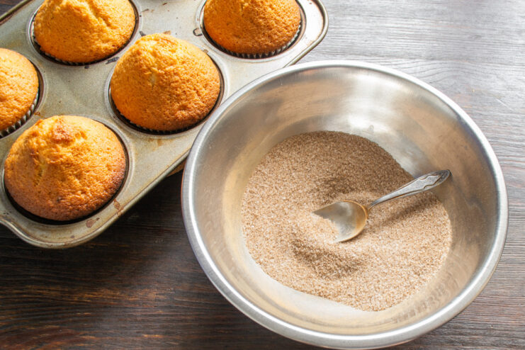 Preparing the cinnamon-sugar coating for the buns. A white bowl with a mixture of sugar and ground cinnamon.