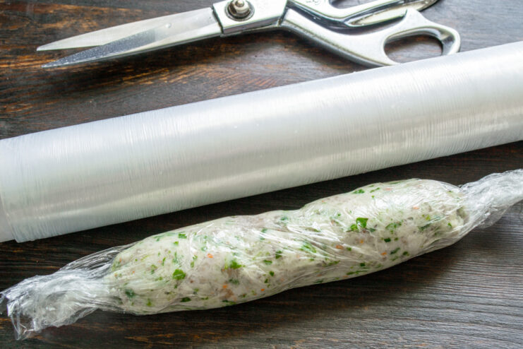 Final step: Chilling the spreadable salo to set the flavors. A log of spreadable salo wrapped in plastic wrap, ready for the freezer.