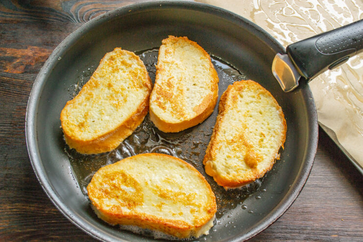 Frying Bread Slices Until Golden Brown Slices of bread being fried to a golden-brown color in a pan.
