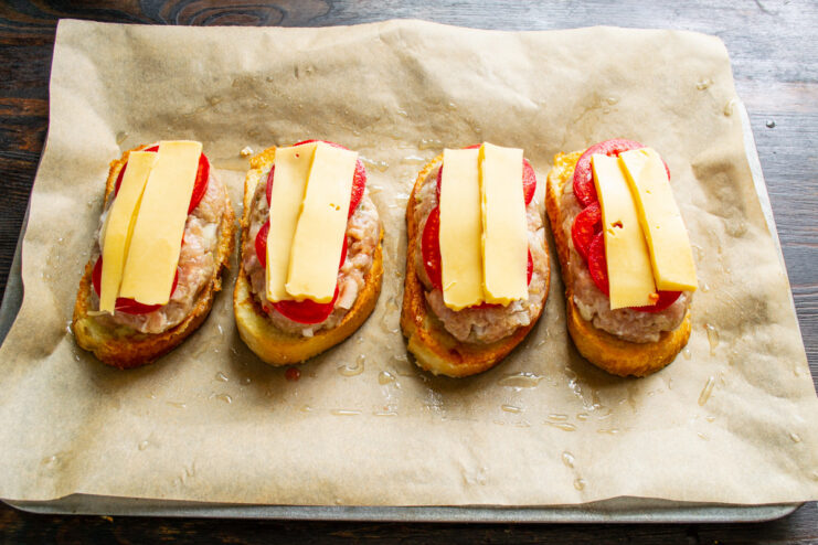 Slicing Cheese into Strips for Topping A block of cheese being cut into narrow strips on a cutting board.