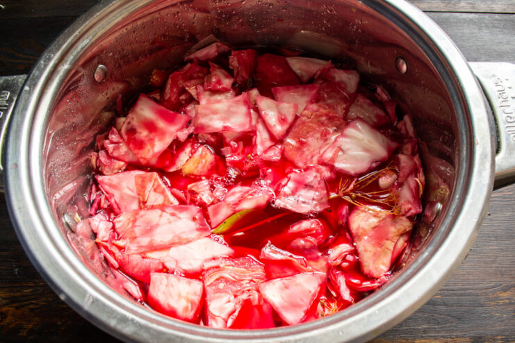 The Pickling Process: Let the Cabbage Ferment for 72 Hours A pot of cabbage pickling on a counter, covered and weighted down.