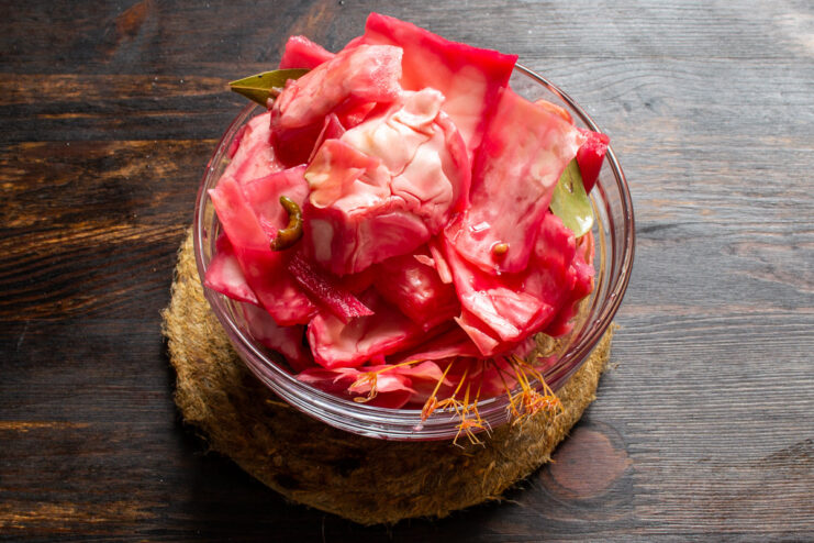 Ready to Eat! Enjoy Your Homemade Pickled Cabbage A serving of vibrant pink pickled cabbage with ginger and beets in a bowl.