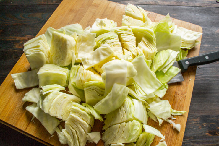 Step-by-Step: Chopping Cabbage into Large Chunks for Pickling Close-up of white cabbage being chopped into large, coarse pieces.