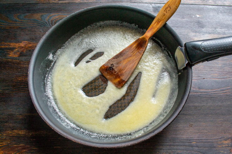 Making the Sauce: Creating a roux with butter and flour Melting butter and whisking in flour in a skillet to make a roux for the sauce.