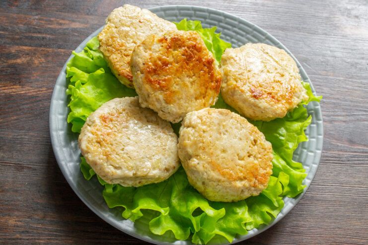 Serving Juicy Baked Chicken Patties A plate of perfectly baked chicken patties served with a fresh green salad.