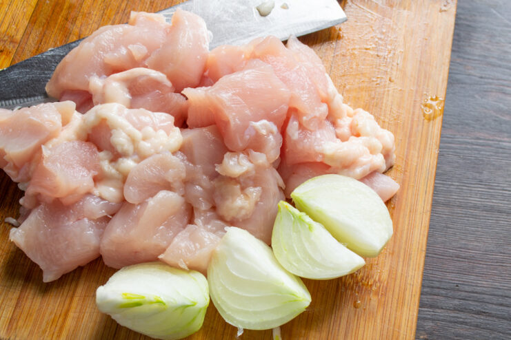 Chopping Onion for Chicken Patties A yellow onion being chopped into small pieces on a cutting board.
