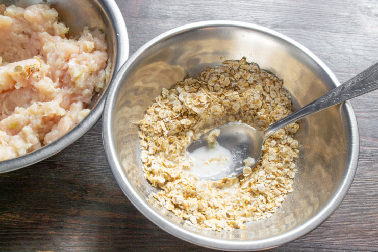Soaking Oats in Milk for Binder A bowl of quick-cooking rolled oats with cold milk being poured over them.