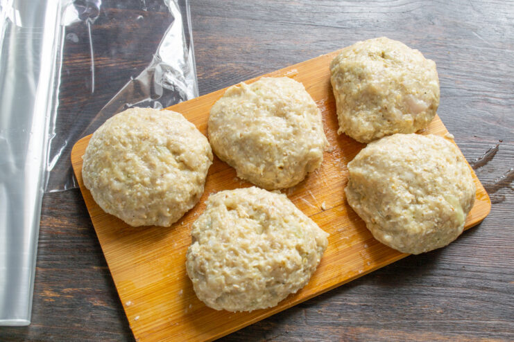 Portioning the Chicken Mixture The ground chicken mixture divided into several equal-sized balls on a cutting board.